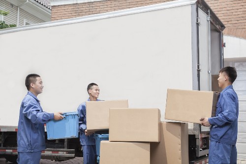 Loading furniture into a van on a residential street in West Green